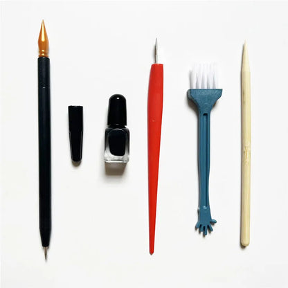 Diamond painting repair tool set with metal scraper pen, bottle of adhesive liquid, soft brush, and bamboo stick on a craft table