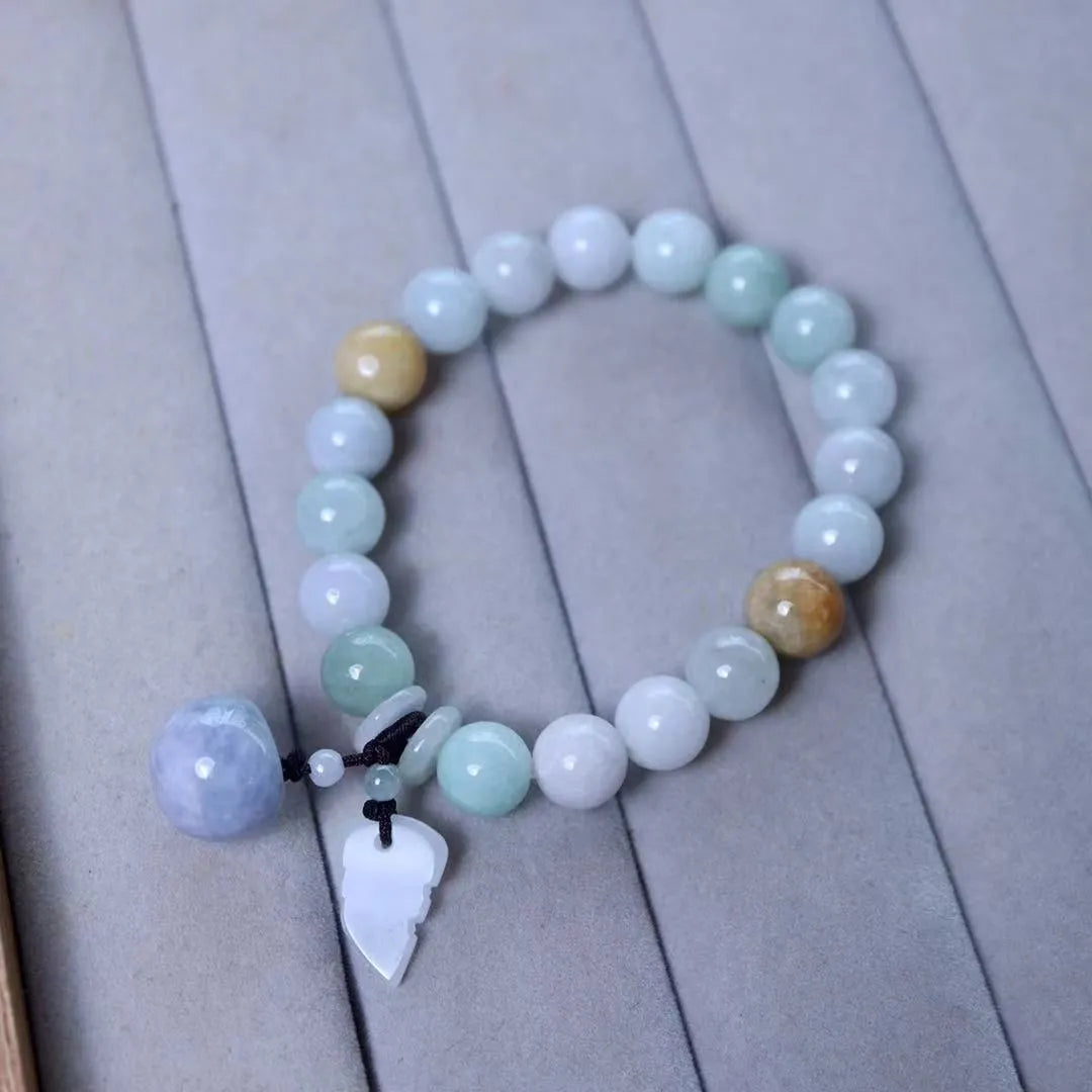 Natural green jade charm bracelet with carved apple and geometric stone pendants.