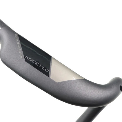 Matt carbon fibre road bike drop handlebar showing bent shape and clamp area.