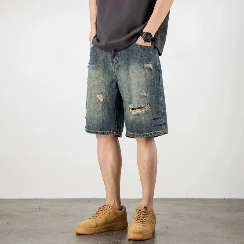 Men's blue loose fit denim shorts with distressed holes and straight leg