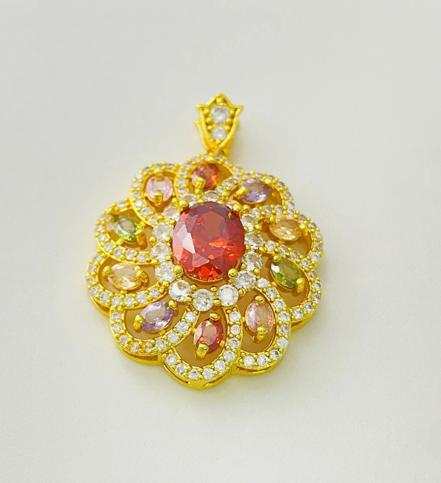 Close-up of a women's flower-shaped pendant necklace with a colourful zircon stone in a choice of gold, champagne gold, or platinum colour finishes.