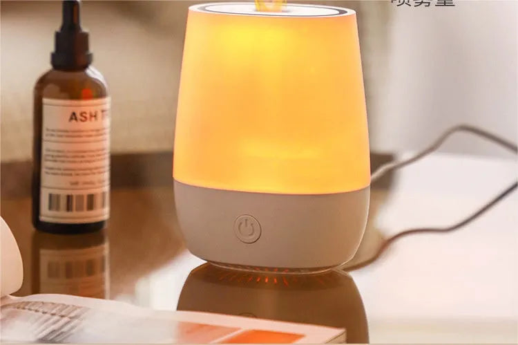White USB aroma diffuser with simulated flame lighting effect on a wooden surface.
