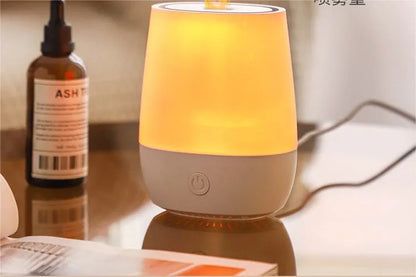 White USB aroma diffuser with simulated flame lighting effect on a wooden surface.