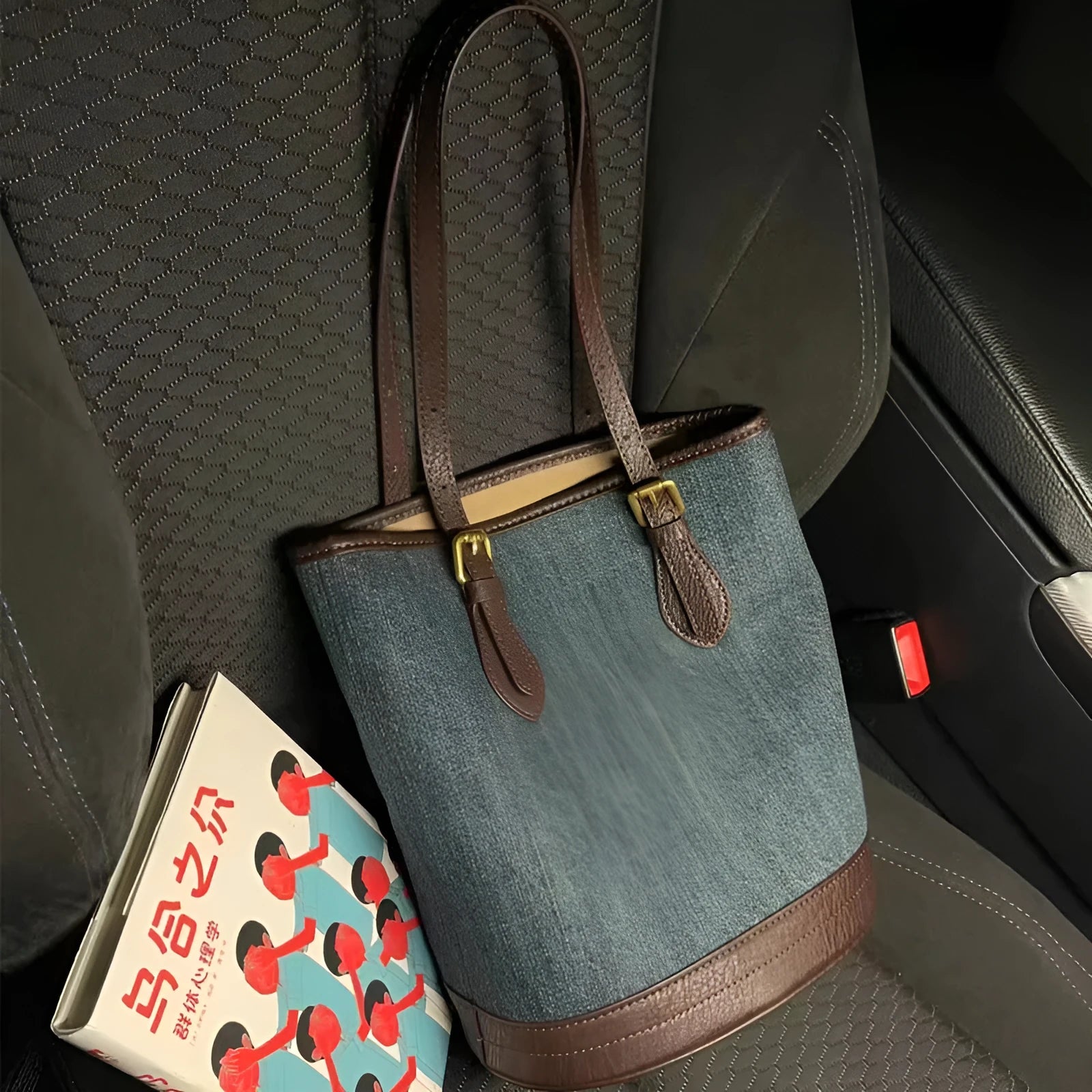 Large blue denim patchwork bucket handbag with one shoulder strap.