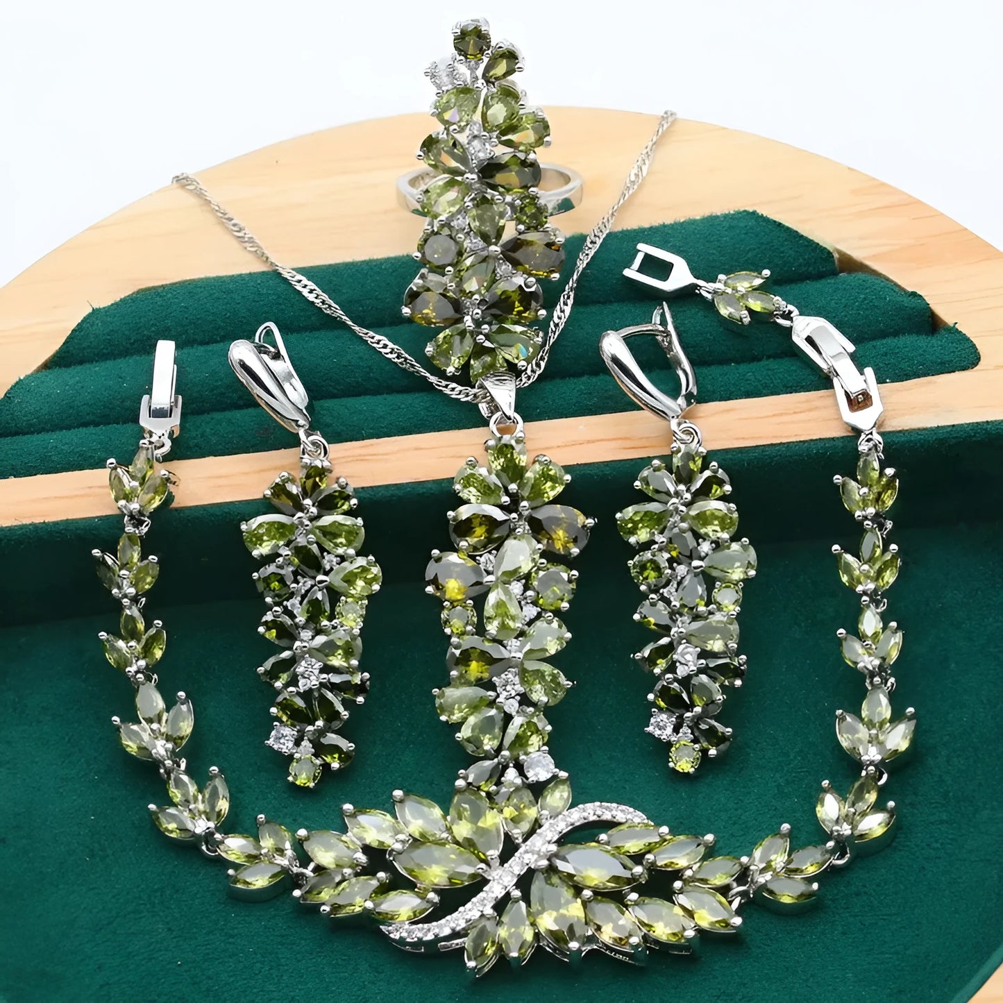Vintage jewellery set with floral patterns showing necklace, bracelet, earrings and ring in olive green colour