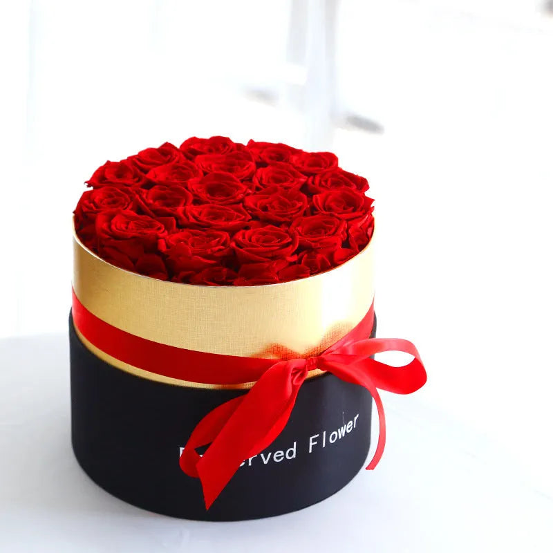 Luxury gift box containing an arrangement of preserved red eternal roses on a dark background.