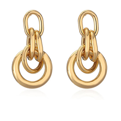 A pair of gold-coloured geometric drop earrings with irregular shapes, made from copper.