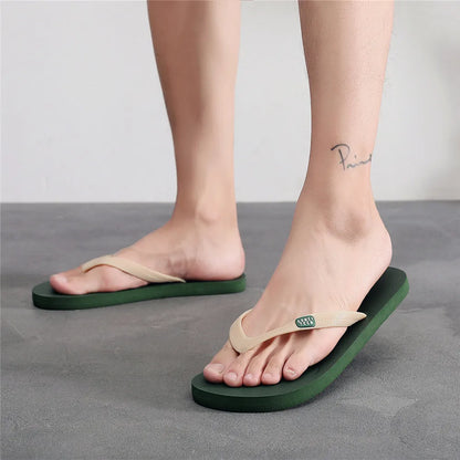 Men's black flip-flop slippers with EVA upper and textured rubber sole on a sandy background.