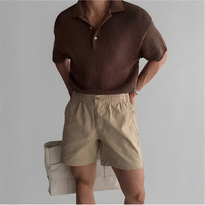 Cotton loose-fit sports shorts in black, shown on a hanger.