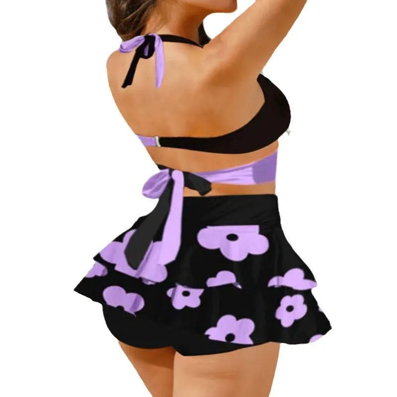 Purple women's bikini and high-waisted skirt swimsuit set with lace-up back detail.