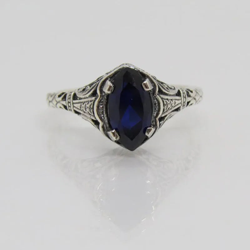 Silver women's ring with geometric hollow pattern and zircon detail on a finger.