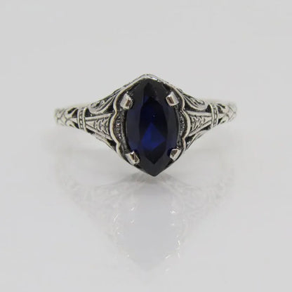 Silver women's ring with geometric hollow pattern and zircon detail on a finger.