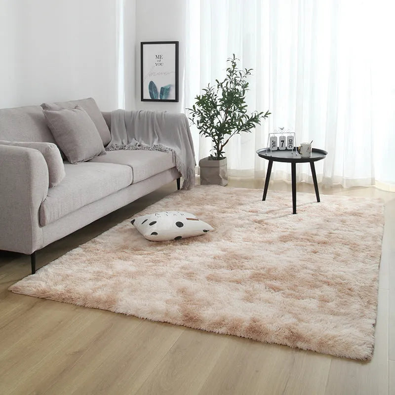 Soft fluffy plain rectangle carpet with anti-slip dots on backing, shown in a light grey colour on a wooden floor.