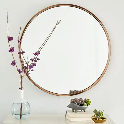 Round metal-framed wall mirror in black, white, or gold for bathroom.