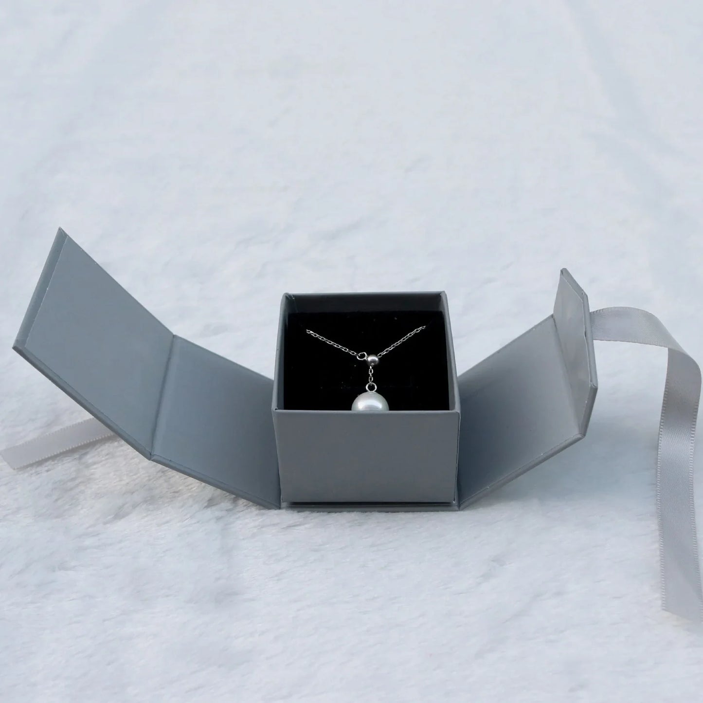 Grey square jewellery box with white ribbon bow measuring 5x5x4cm with sponge-lined interior