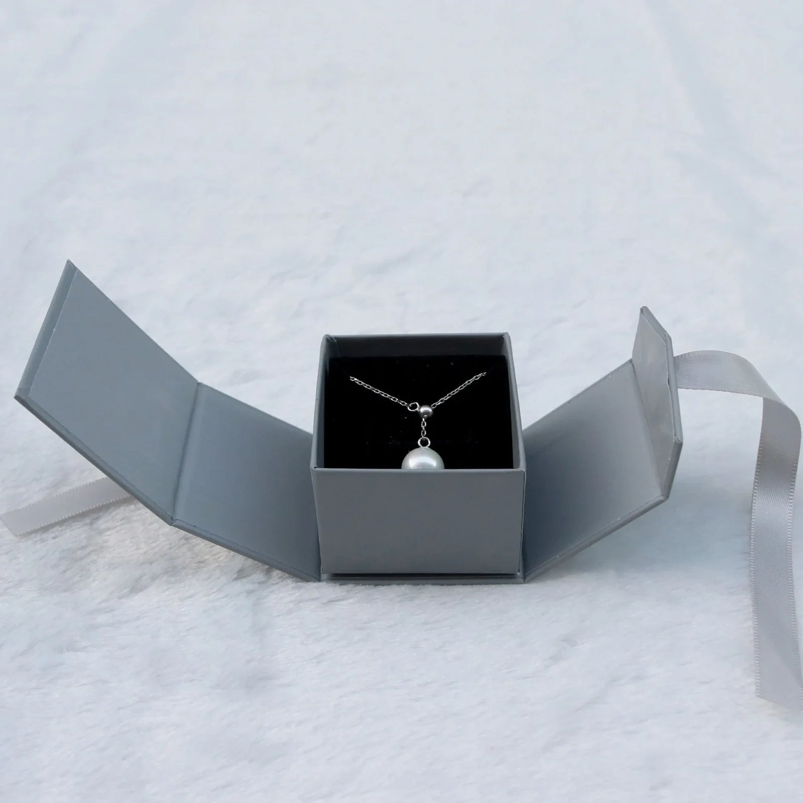 Grey square jewellery box with white ribbon bow measuring 5x5x4cm with sponge-lined interior