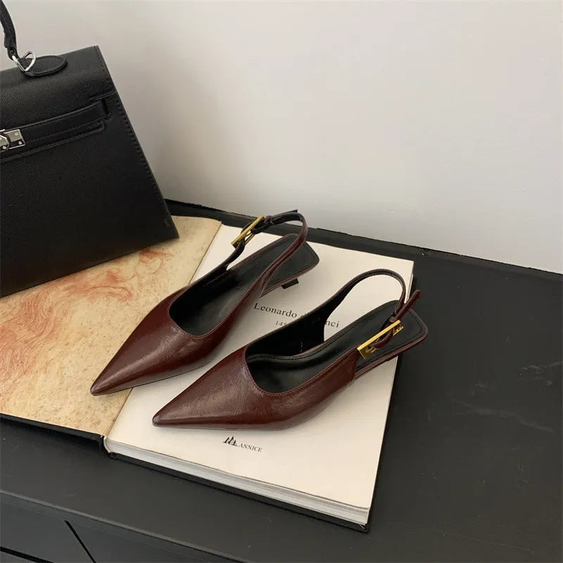 Women's black leather pointed toe shoes with low heel and thin strap.