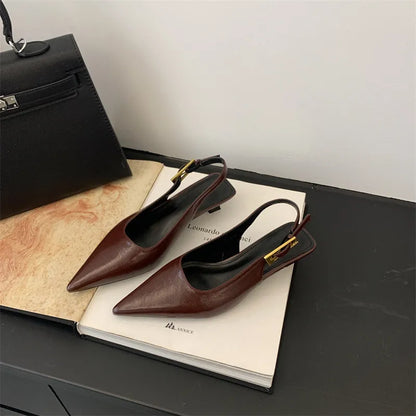 Women's black leather pointed toe shoes with low heel and thin strap.