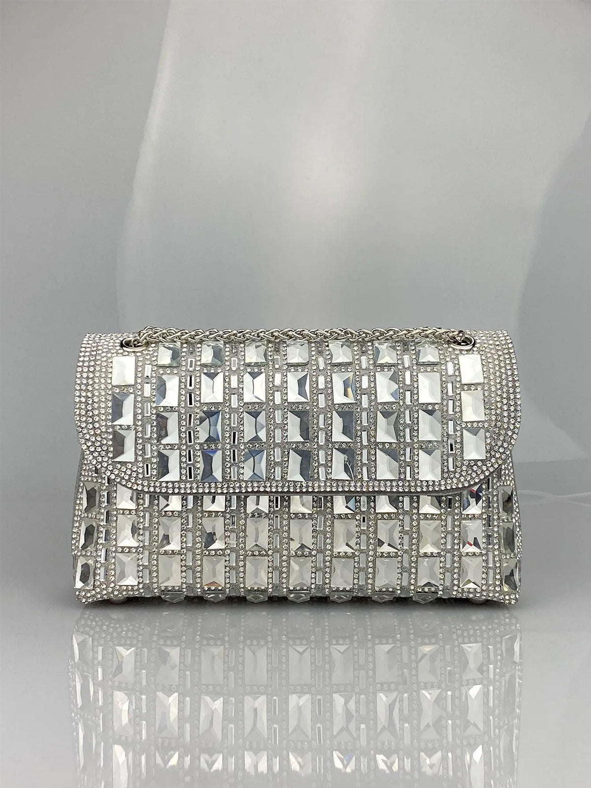 Silver rhinestone-decorated PU leather clutch bag with a metal chain strap, shown open to reveal interior phone pocket.