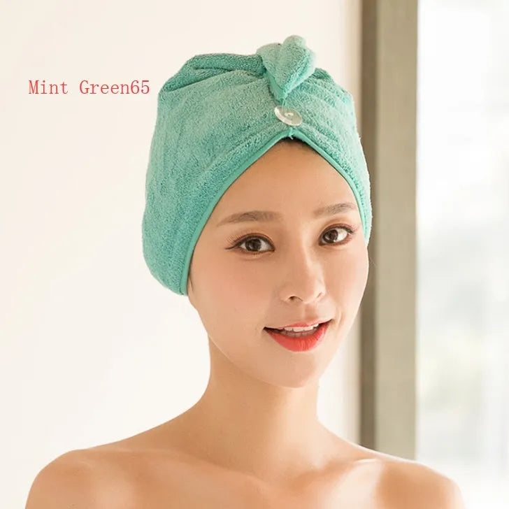 A woman wearing a sky blue microfiber hair dryer cap, with wet hair tucked inside, showing the towel's wrap-around design.