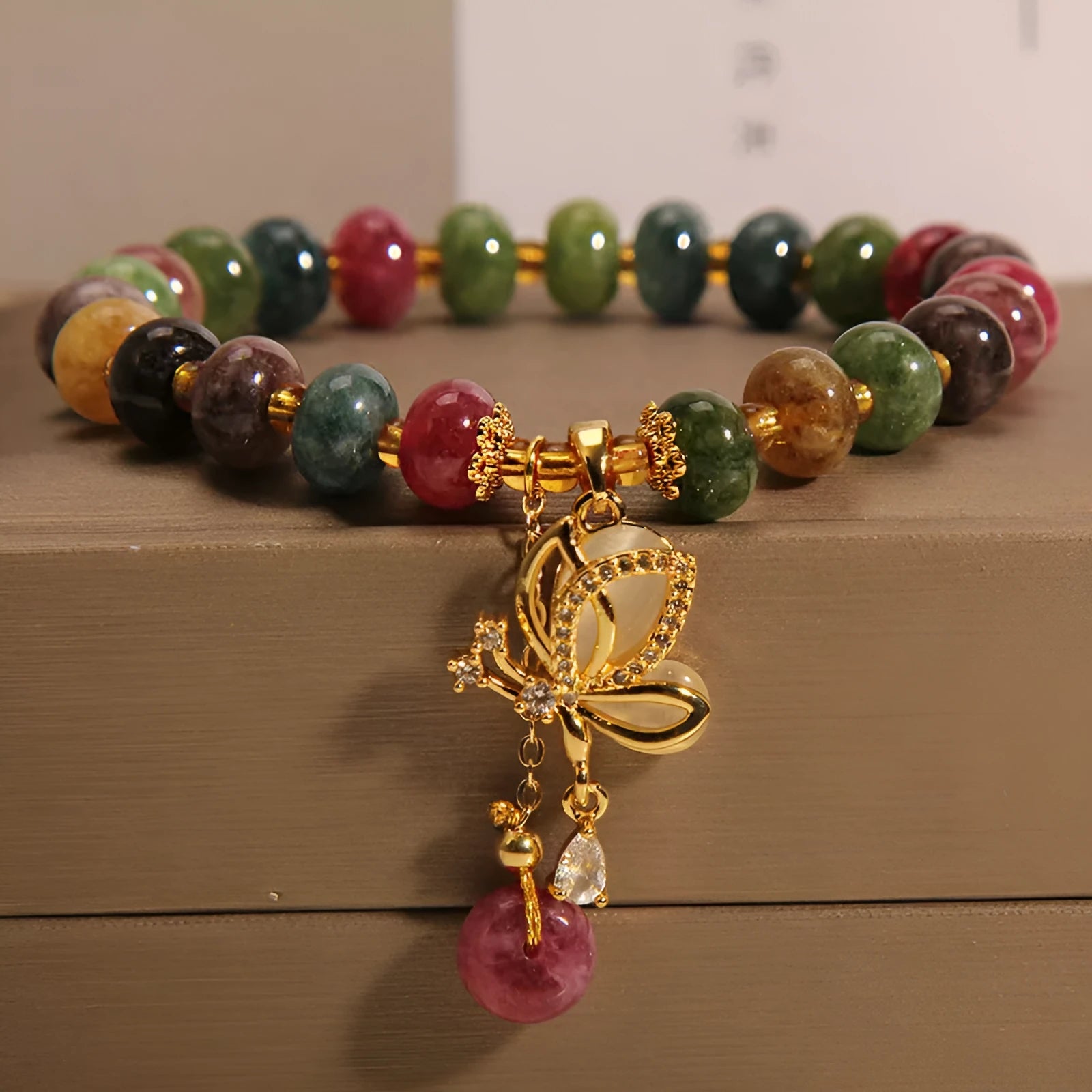 Close-up of a women's colourful butterfly bracelet with alloy construction, colourful beads, and tourmaline details.