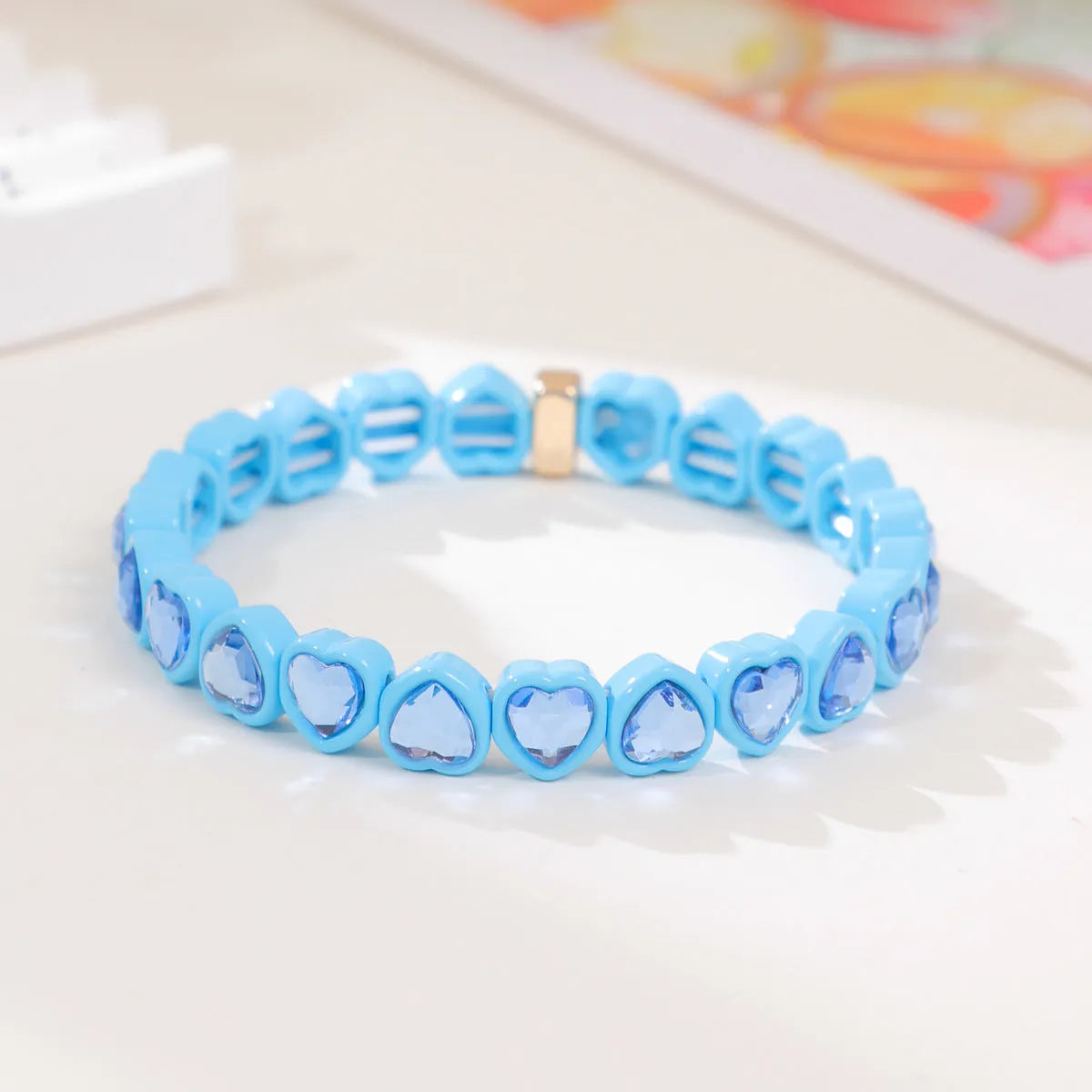 Colourful enamel heart shape on a silver-toned alloy stretch bracelet.