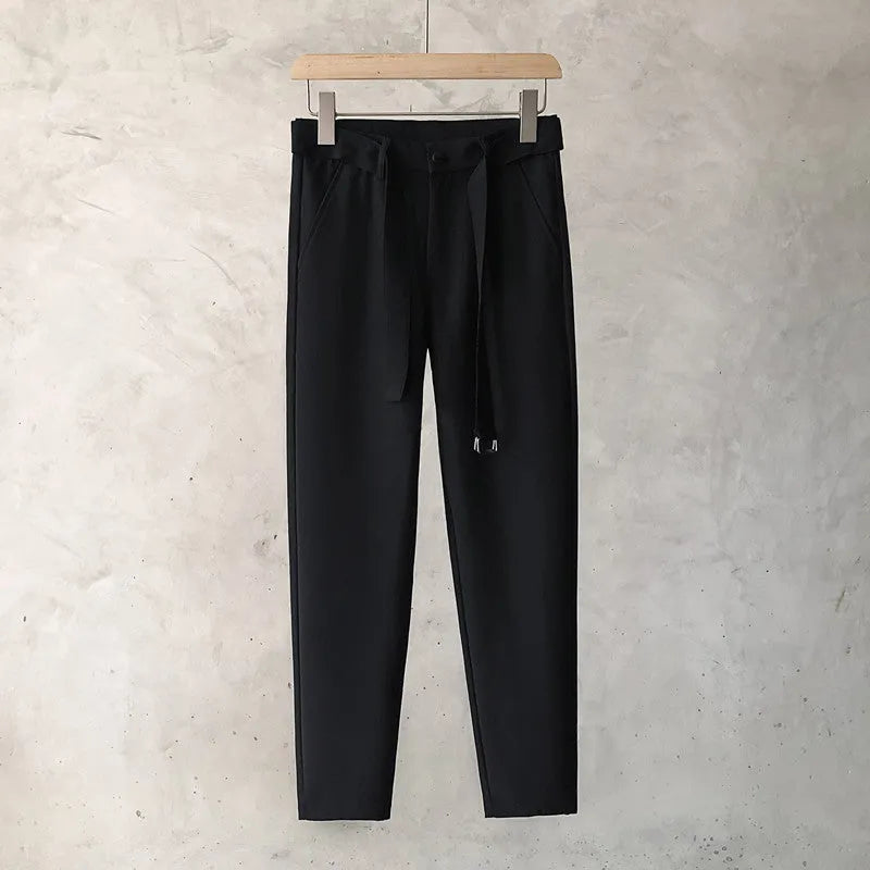Boys slim straight wool trousers in tapered fit on hanger, showing straight leg opening.
