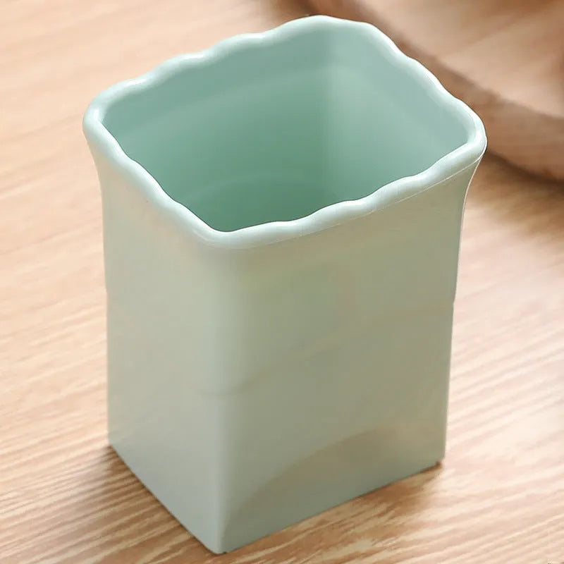 Green stainless steel cup-shaped kitchen slicer for cutting fruits and eggs on a countertop.
