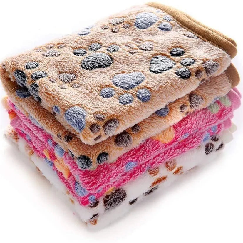 Coral fleece dog blanket with paw print pattern, shown in beige colour, laid flat to show size and soft texture.