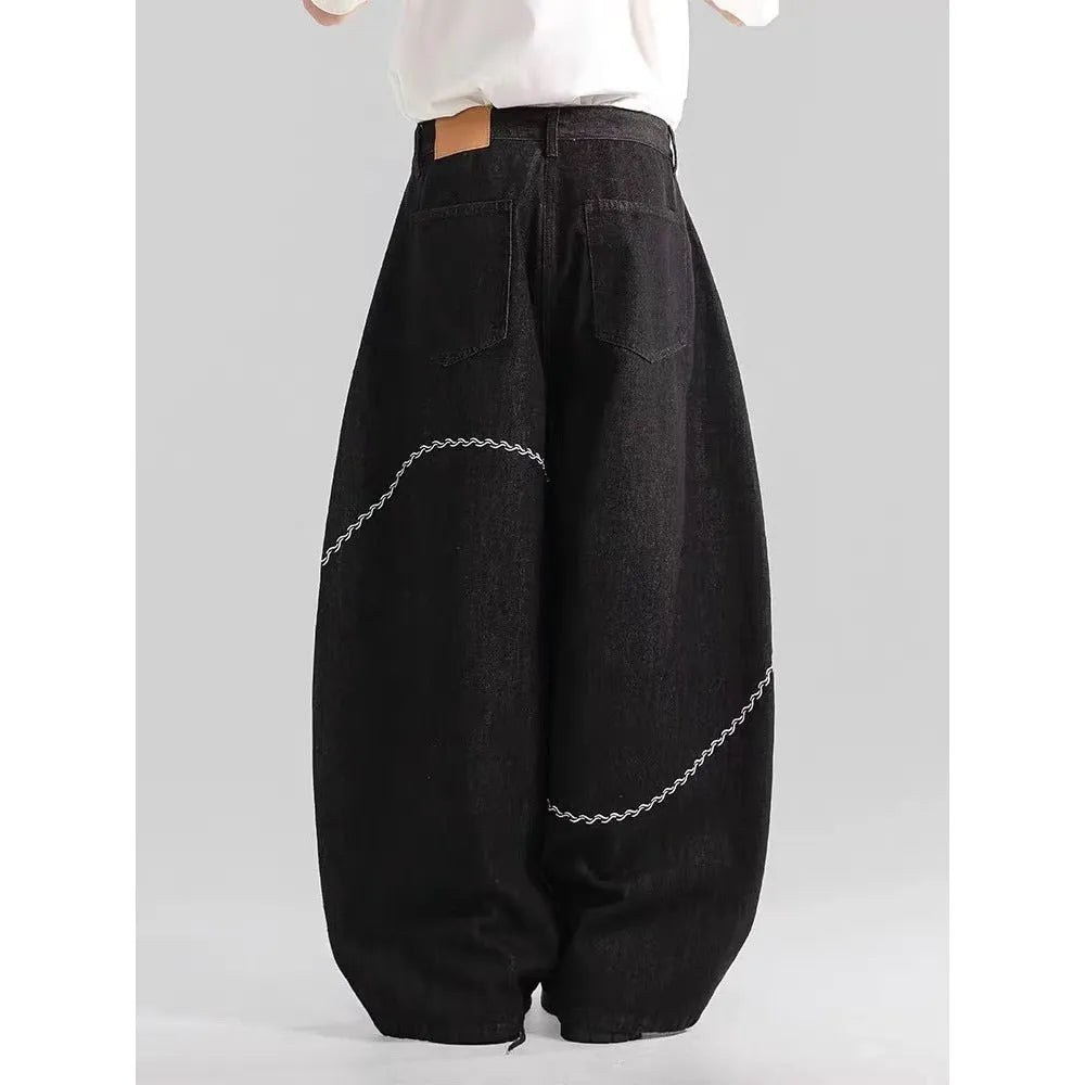 Men's black straight-leg denim trousers on a hanger, showing mid waist and zip fly detail.