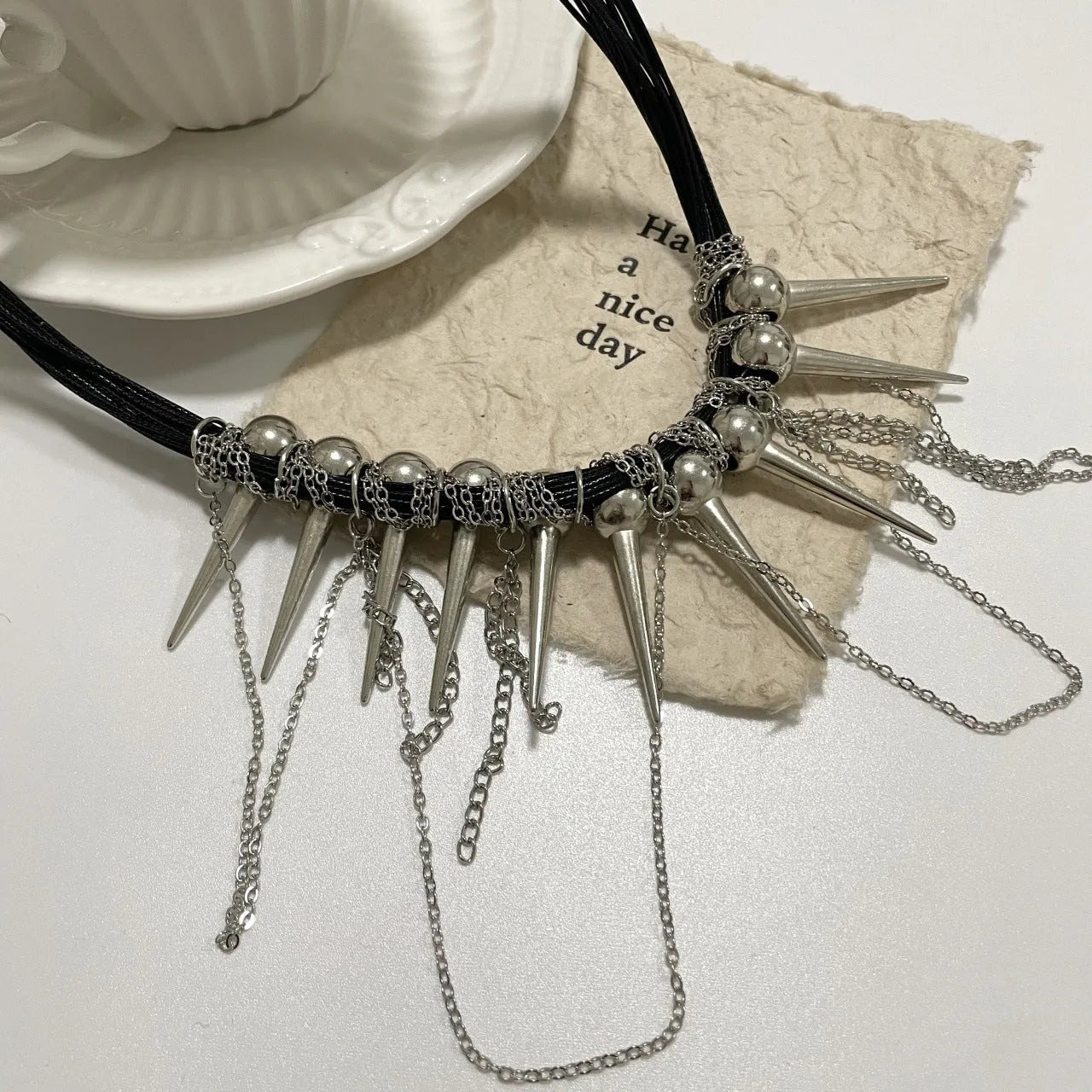 Women's casual leather necklace with winding round beads, a tassel, and decorative point rivets in pictured colour.