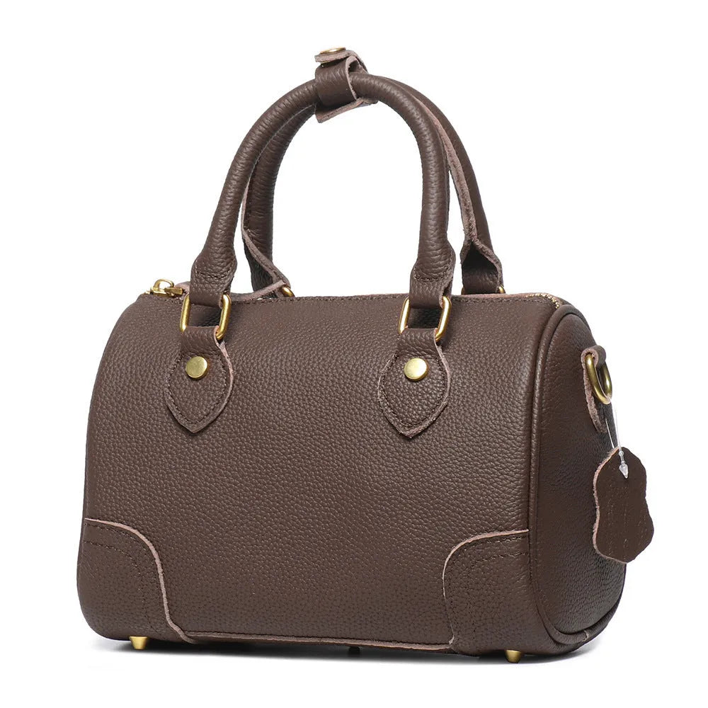 Handmade cylindrical brown Boston bag made from first layer cowhide leather with a single shoulder strap.