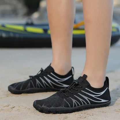 Men's and women's low-top breathable sports running shoes with a natural rubber sole on a hard ground surface.