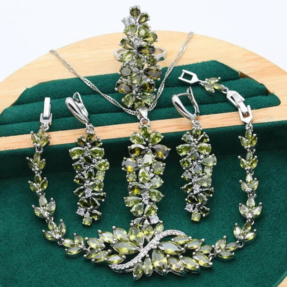 Vintage jewellery set with floral patterns showing necklace, bracelet, earrings and ring in olive green colour