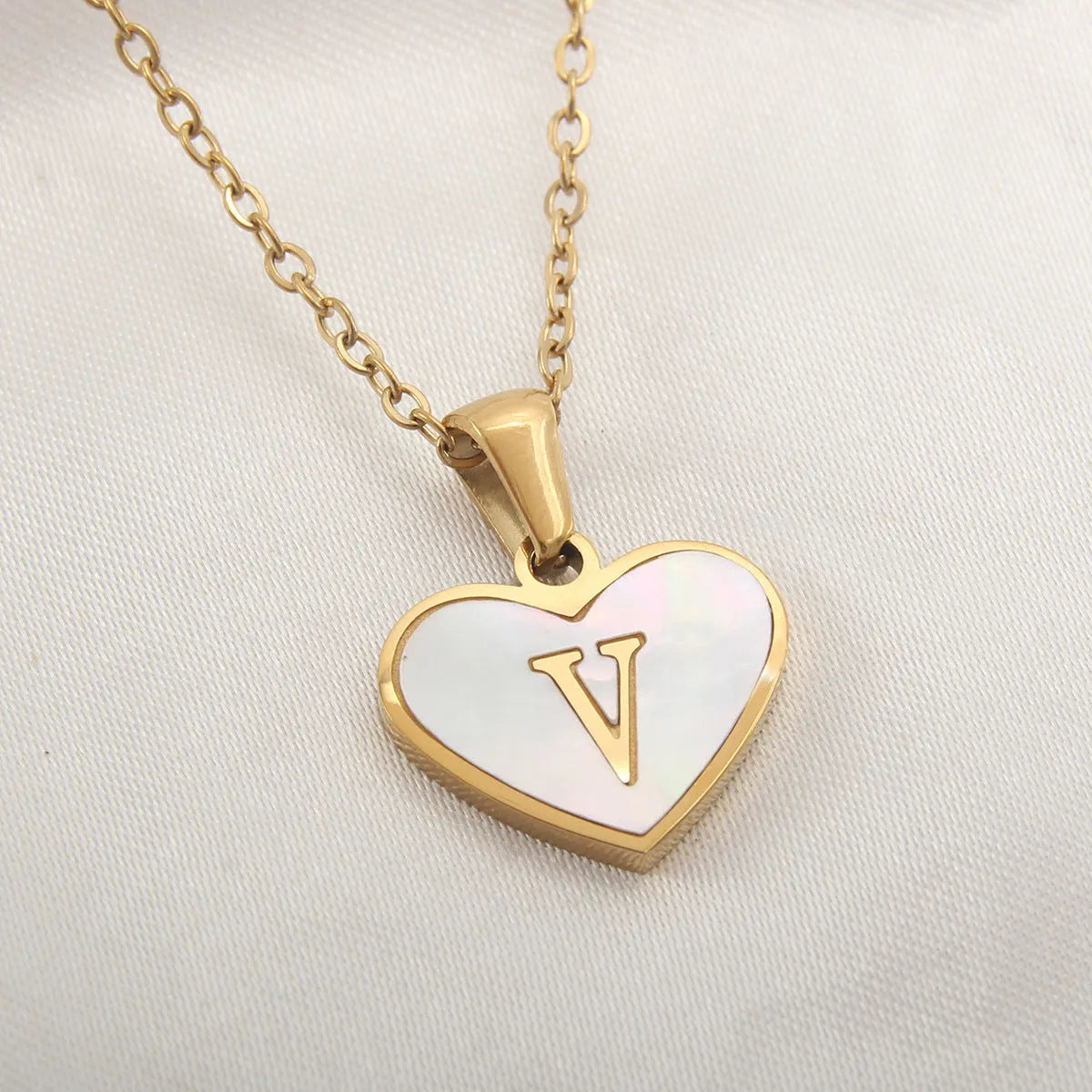 Gold-plated heart necklace with white shell pendant showing letter personalisation option