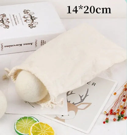 A 100% wool drying ball for laundry next to a plain cotton storage bag on a background.