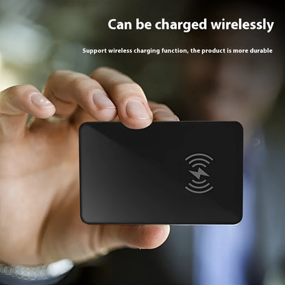 Black card-sized pet tracker with wireless charging and a hanging hole for collar attachment