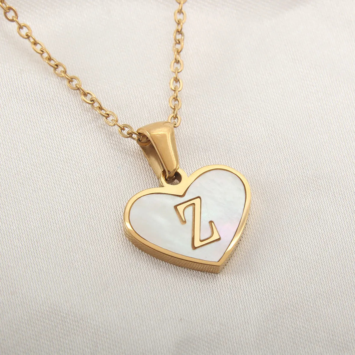 Gold-plated heart necklace with white shell pendant showing letter personalisation option