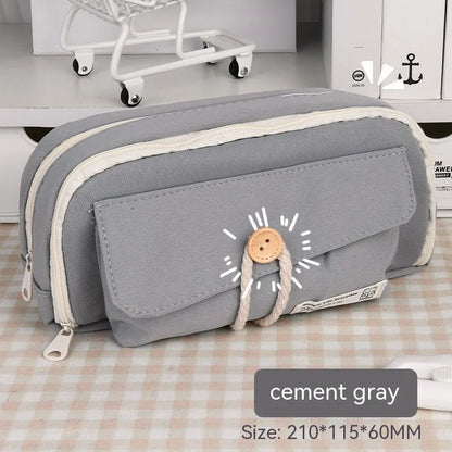 Korean style canvas pencil case with button closure, shown in beige, holding multiple pens.