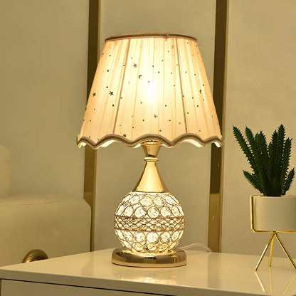 Gold crystal desk lamp with hand-cut facets and remote control on wooden surface