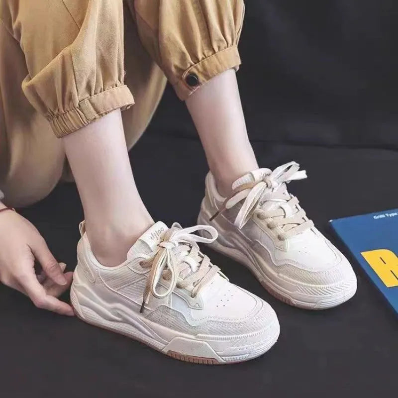 Pink and milky white low-top height-increasing sneakers with a rubber sole.