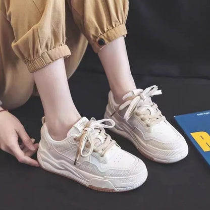 Pink and milky white low-top height-increasing sneakers with a rubber sole.