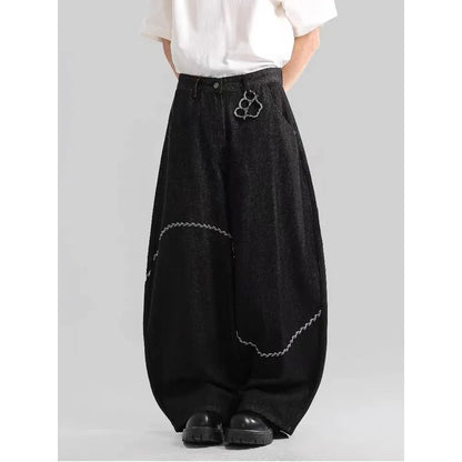 Men's black straight-leg denim trousers on a hanger, showing mid waist and zip fly detail.