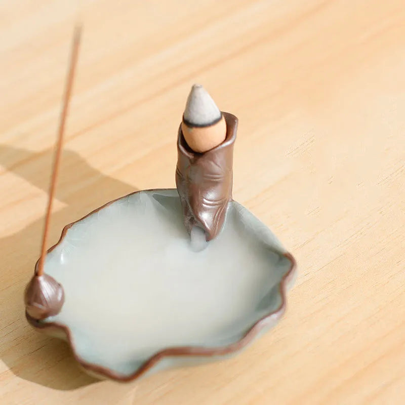 Square ceramic incense burner with reverse flow design showing smoke cascading down sides, Ge kiln crackle glaze patterns visible