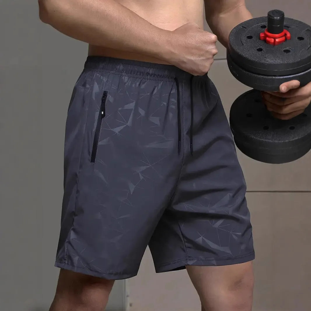 Man wearing loose-fit grey printed sports shorts with elastic waistband, showcasing the above-knee length.