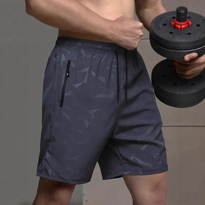 Man wearing loose-fit grey printed sports shorts with elastic waistband, showcasing the above-knee length.