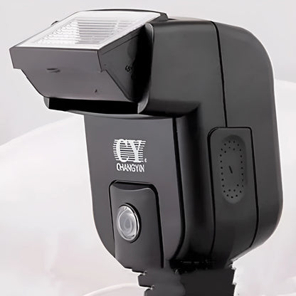 Compact black hot shoe camera flash with its head tilted upwards, showing the flash bulb and hot shoe mount.