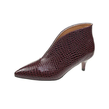 Women's black V cut Martin boots with a pointed embossed toe and a chunky heel.