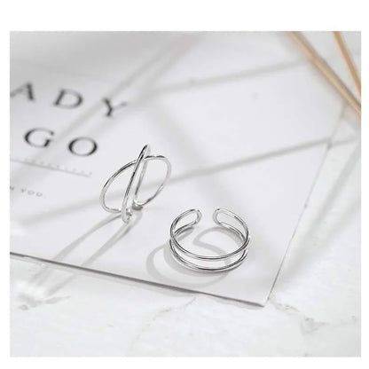 Silver plated geometric cross ring for women with adjustable opening on a white background