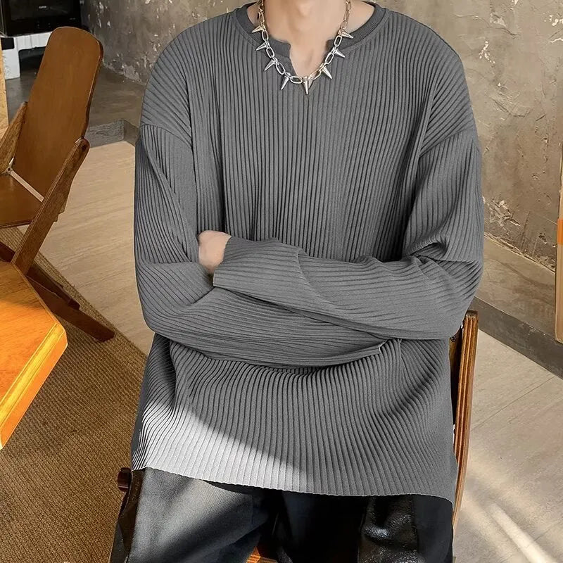 A woman wearing a black and white striped, loose-fit, long-sleeve pullover jumper.